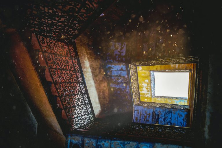 Sunlight and dust motes streaming through a window onto a staircase