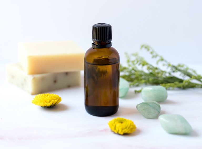 Soap bars, an amber essential-oil bottle and gemstones on a table