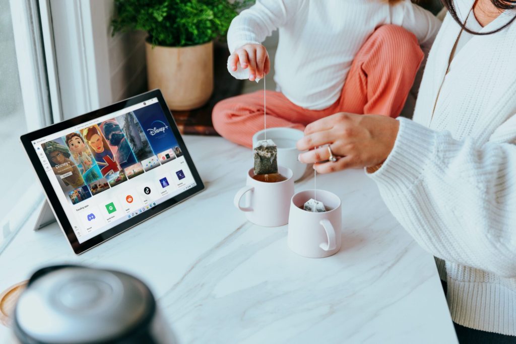 A person with coffee and a tablet relaxing at a table at home