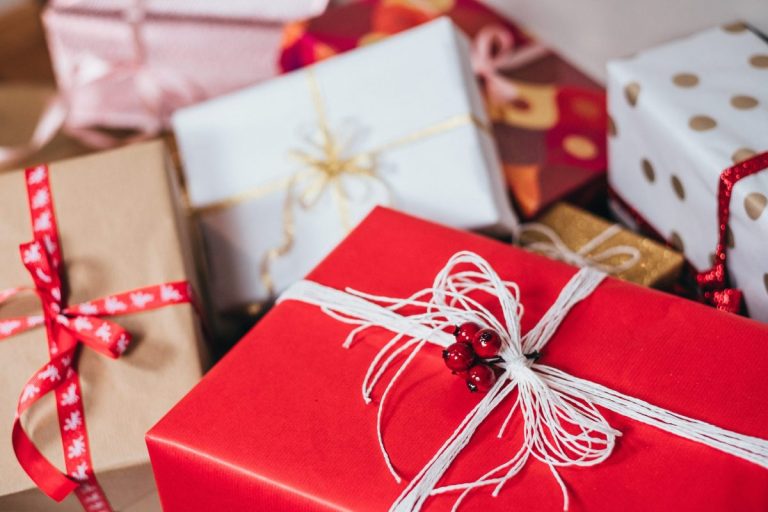 Wrapped holiday gifts with a red ribboned present on top