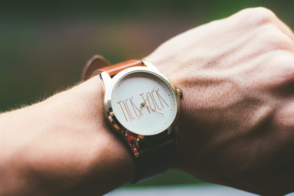 Close-up of a wristwatch face reading tick tock